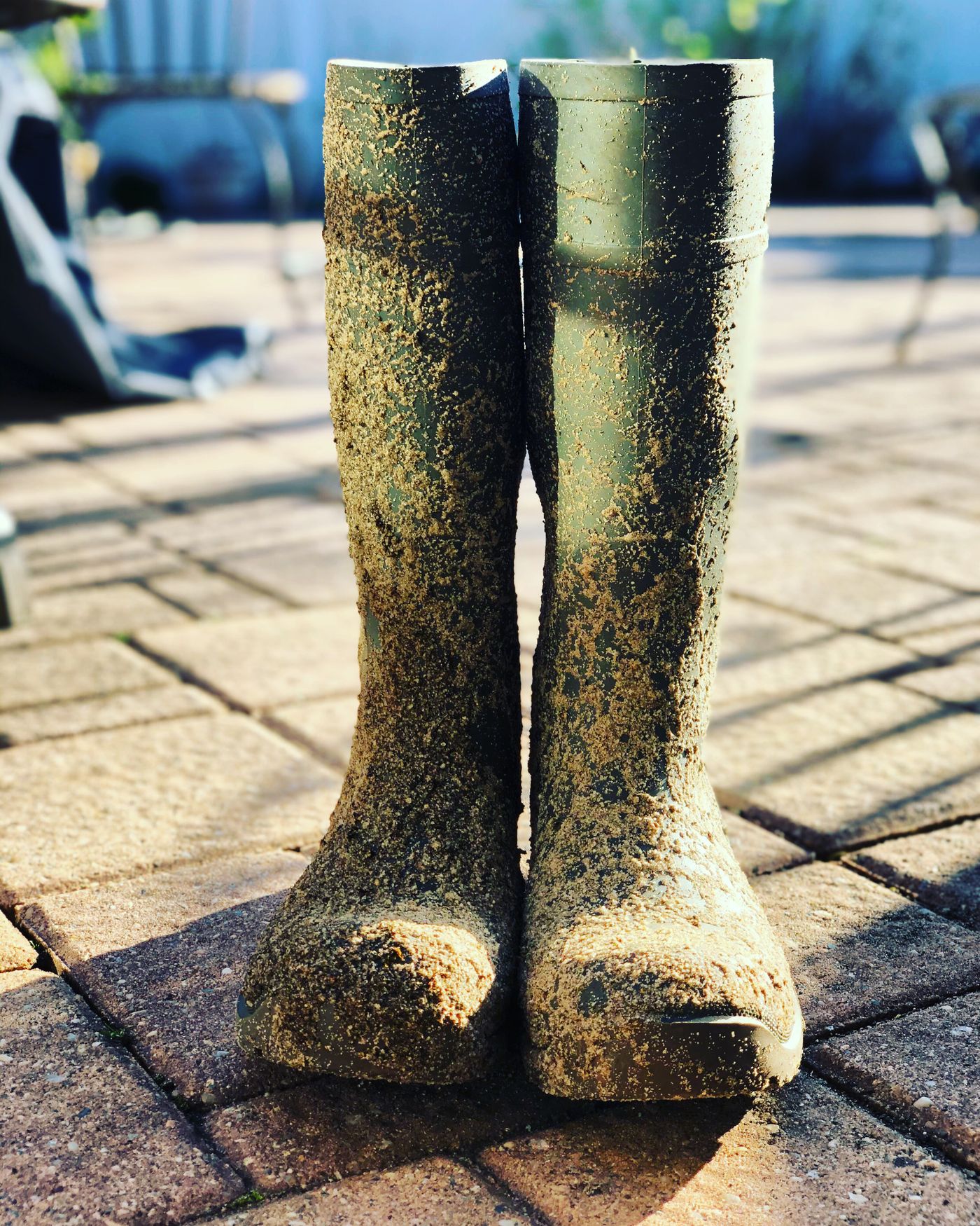 Muddy boots standing on a brick pavement