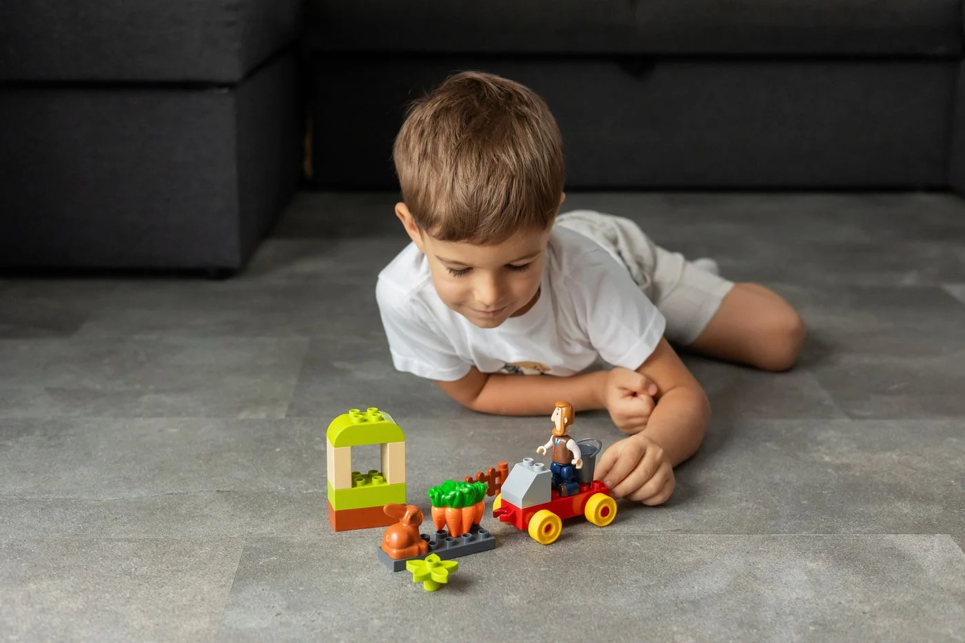 Child playing with colorful toy blocks on an indoor floor