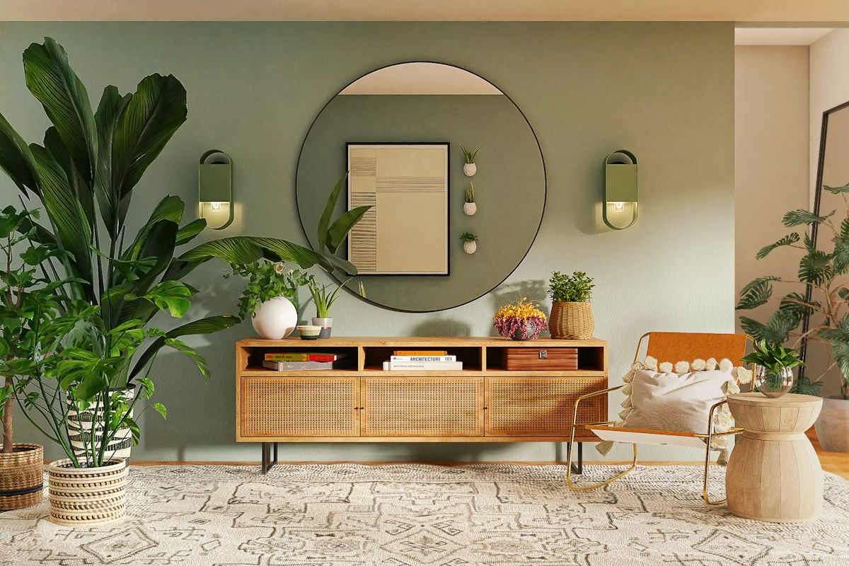 A wooden dining table and bench beside a round mirror and indoor plants