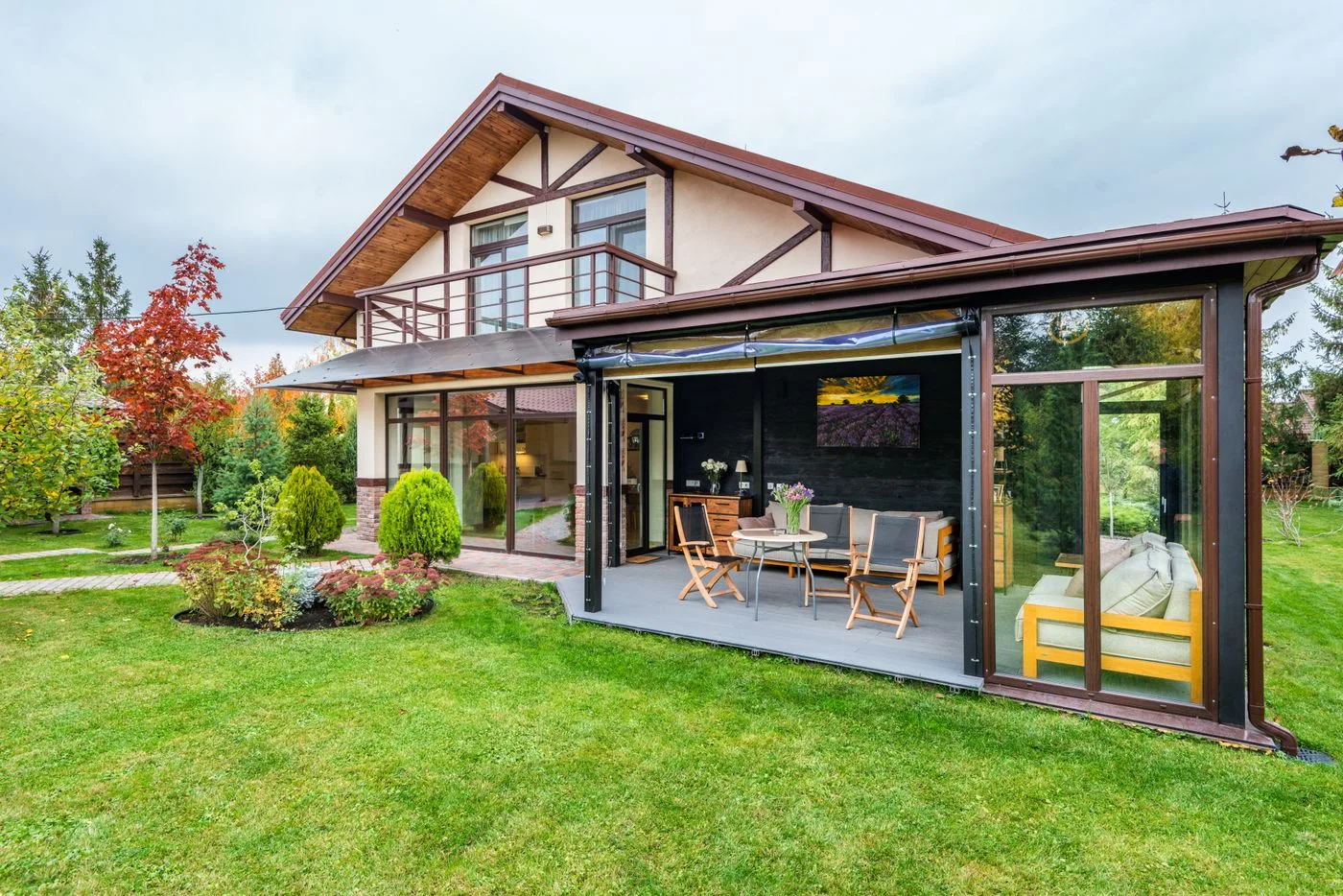 A house with a covered terrace and green garden lawn